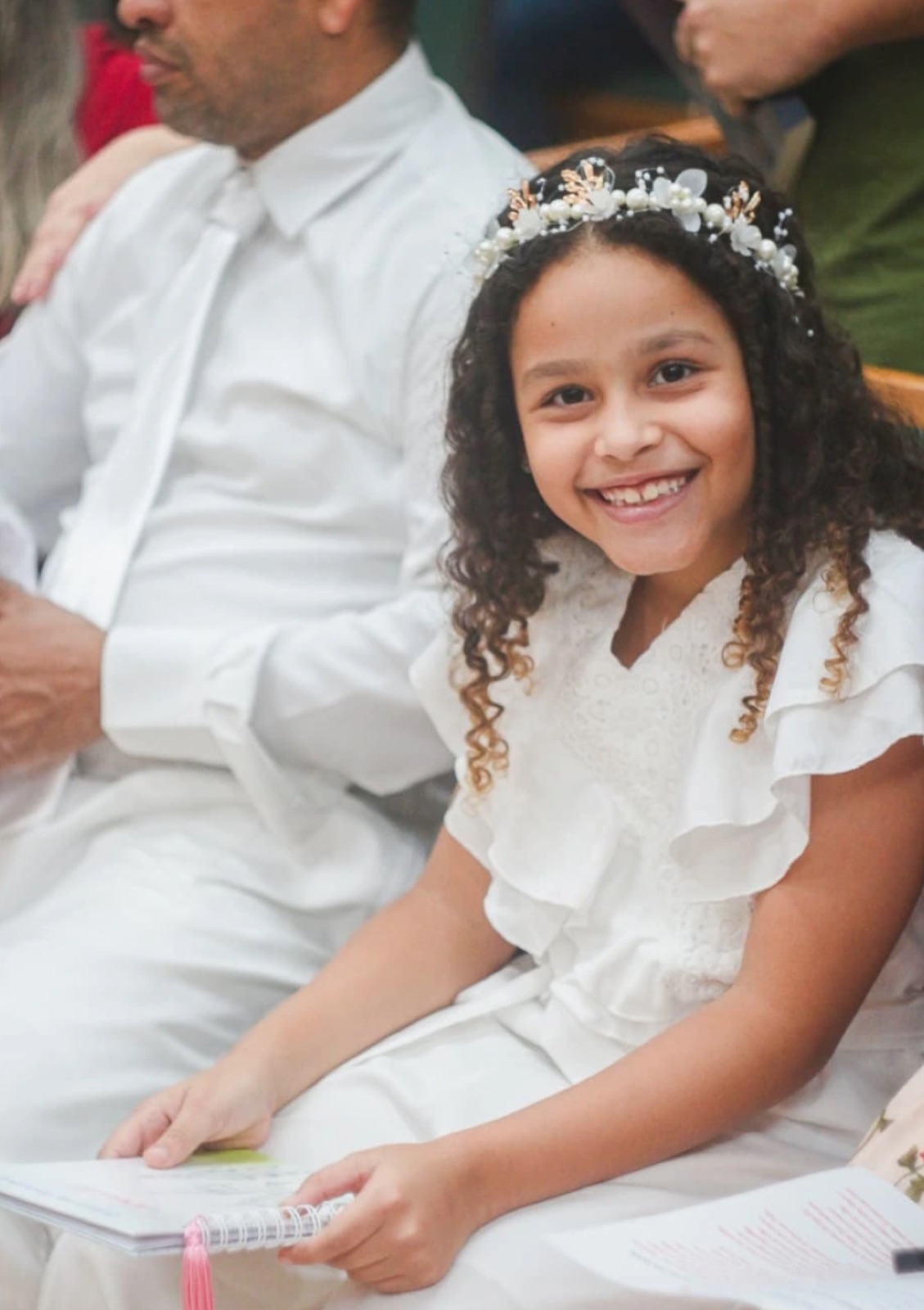 Menina sorrindo em vestido de comunhão