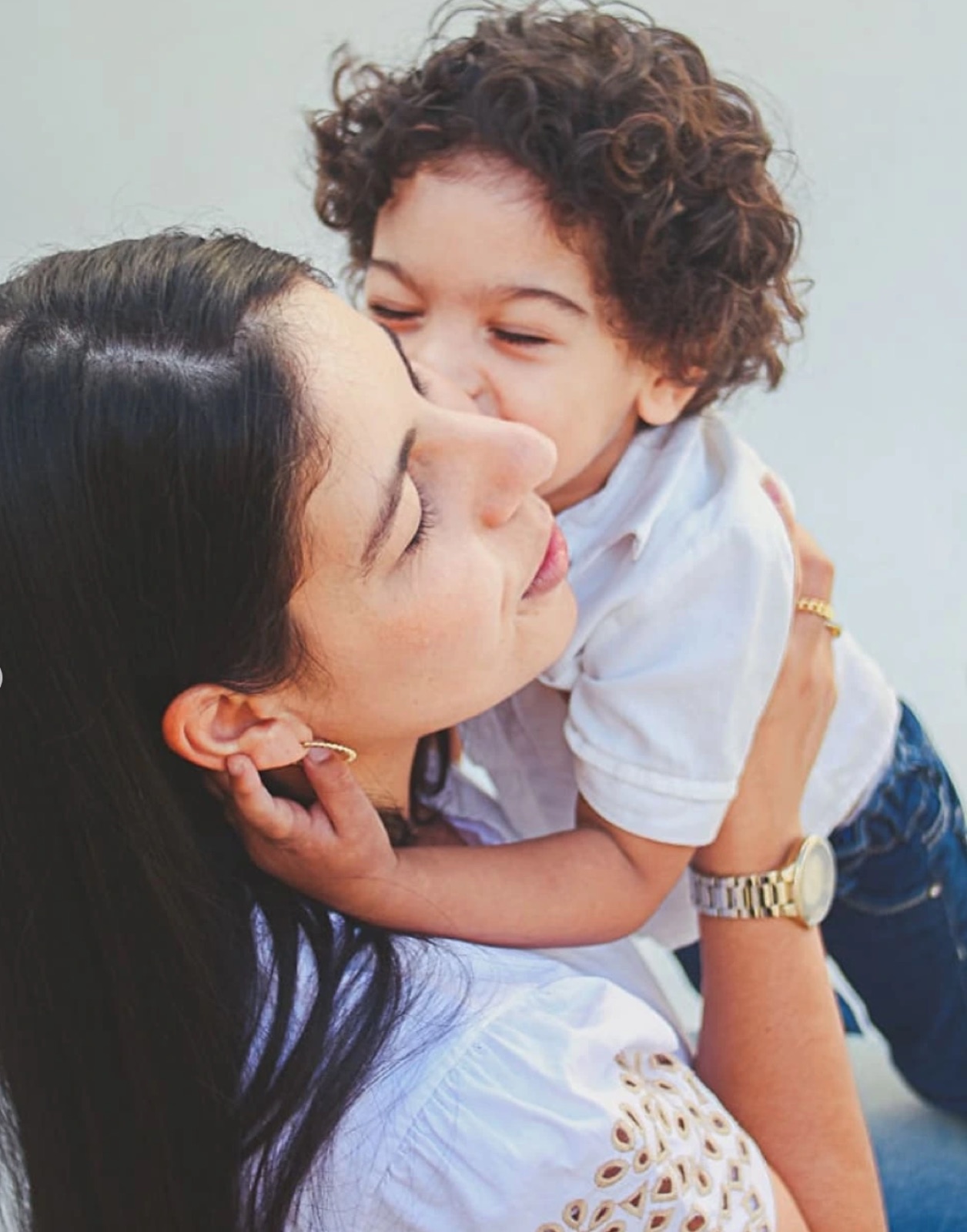 Mãe beijando o filho pequeno no rosto