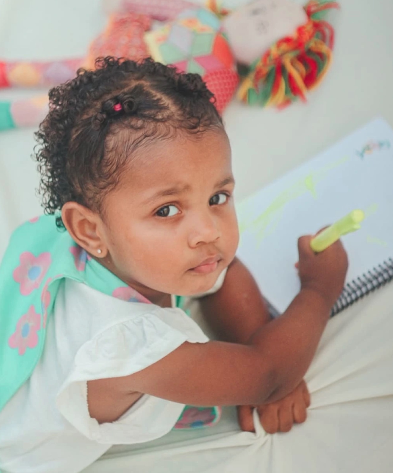 Bebê desenhando, olhando para a câmera