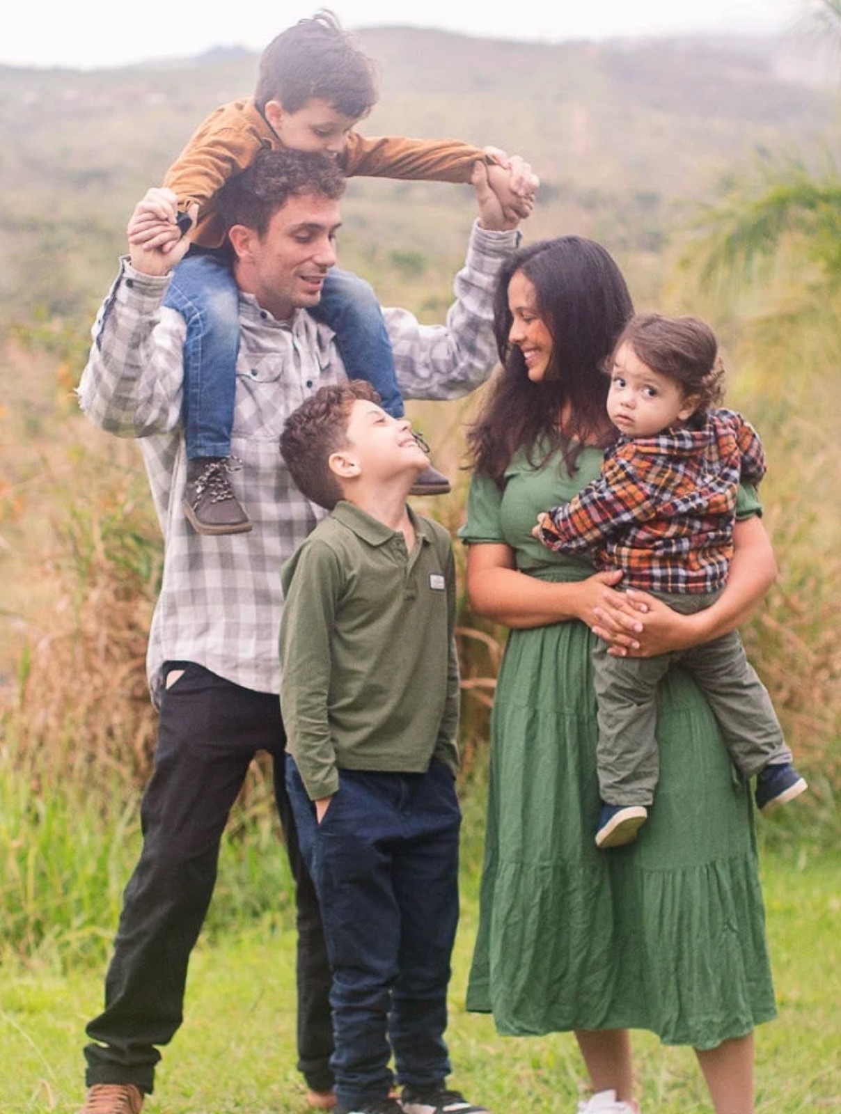 Família com três crianças brincando ao ar livre