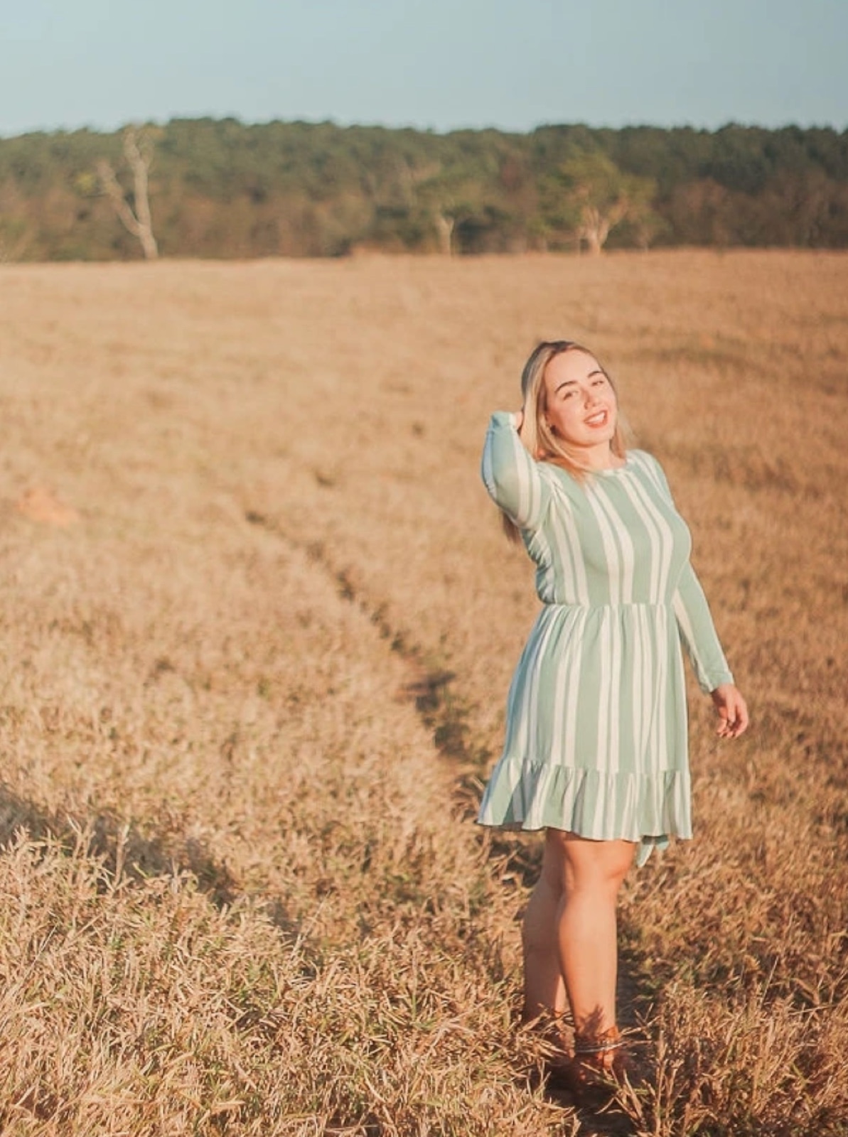 Mulher em vestido listrado em campo dourado